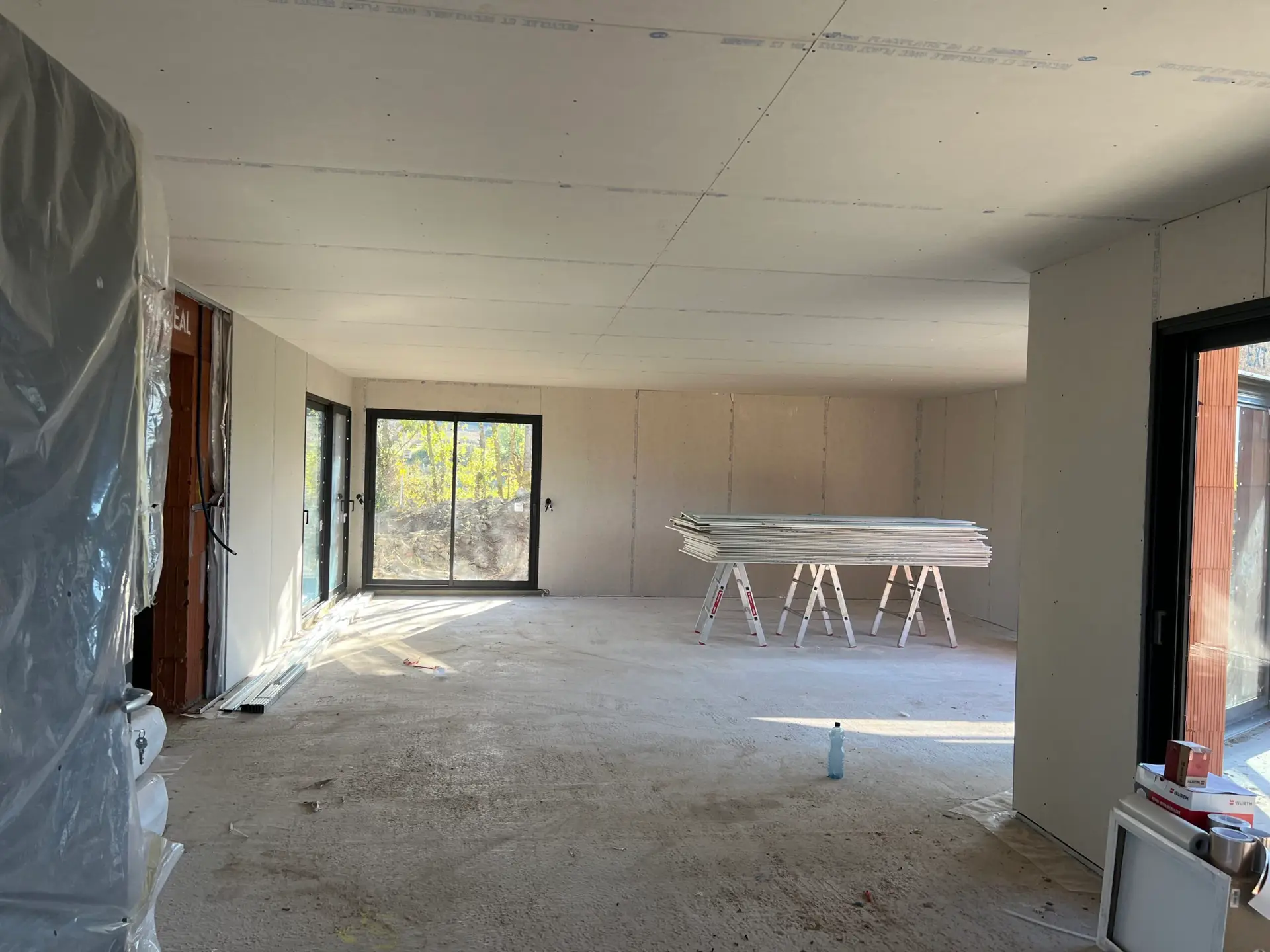 pièce d’une maison en cours de travaux avec fenêtres coulissante